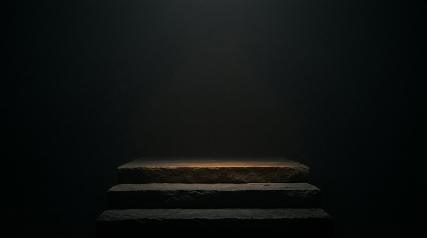 Three shallow stone steps rising into the dark, the top step lit with a warm edge.